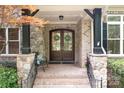 Charming covered front entrance showcasing double doors with wreaths and stone accents at 3204 Mcpherson St, Waxhaw, NC 28173