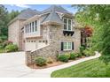 Stone detailing and landscaping surround the side exterior and three car garage at 3204 Mcpherson St, Waxhaw, NC 28173