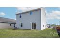 Spacious backyard featuring a well-maintained lawn and a sliding glass door for easy access at 3323 Burberry Dr, Gastonia, NC 28052