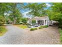 Well-maintained home nestled on a lot with mature trees and a gravel driveway at 34 Admiral Sw Ave, Concord, NC 28027