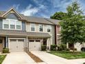 Beautiful townhome showcasing stone details, a driveway, well-kept lawn, and lush tree at 403 Park Meadows Dr, Matthews, NC 28104