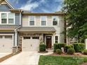 Inviting front view of a townhome with stone accents, well-kept landscaping, and a driveway at 403 Park Meadows Dr, Matthews, NC 28104