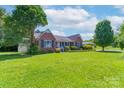 Attractive brick home featuring a manicured lawn, mature trees and a covered carport at 500 Belleview Rd, Rock Hill, SC 29730