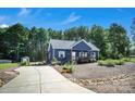 A long driveway leads to a beautifully landscaped blue home with vibrant flowers and a convenient storage shed at 5016 Old Pine Ln, Cherryville, NC 28021