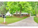 Ranch-style home with mature trees, long driveway, and well-maintained lawn at 504 Amon Ln, Pineville, NC 28134