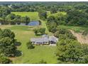 Picturesque aerial view of a home with a pond, surrounded by lush greenery and mature trees at 714 Helms Efird Rd, Marshville, NC 28103