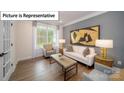 Bright living room with a grey accent wall, modern furniture, and natural light at 7184 Sylvan Retreat Dr, Denver, NC 28037