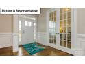 Bright foyer featuring hardwood floors, elegant trim work, and glass-paneled french doors leading to another room at 7196 Sylvan Retreat Dr, Denver, NC 28037