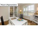 Sunlit office featuring a white desk, hardwood floors, and large windows offering a pleasant view at 7196 Sylvan Retreat Dr, Denver, NC 28037