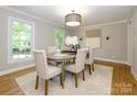 An elegant dining room with neutral decor, a round table, and large windows at 7356 Terrace Dr, Charlotte, NC 28211