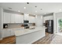 Modern kitchen with white cabinets, stainless steel appliances, a spacious island, and light wood flooring at 1015 Maltby St, Charlotte, NC 28217