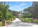 Long driveway lined with trees leads to brick home in wooded area at 102 Antioch Plantation Dr # 18, Matthews, NC 28104