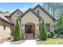 Beautifully crafted home entrance features brick façade, manicured landscaping, and inviting black front door at 102 Antioch Plantation Dr # 18, Matthews, NC 28104