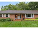 Inviting front entrance of brick home with a well-kept lawn and white door framed by traditional shutters at 1081 Long Dr, Newton, NC 28658