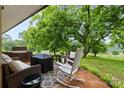 Relaxing outdoor patio with comfortable seating, a brick fireplace, and a serene view of the backyard at 1081 Long Dr, Newton, NC 28658
