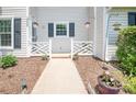 Close-up of home entrance; white fence, manicured flower beds, and inviting pathway at 10945 Winterbourne Ct, Charlotte, NC 28277