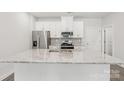 Modern kitchen features stainless steel appliances and granite countertops at 124 Utility Ln # E, Mooresville, NC 28117