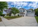 Street view of a charming two-story home with a welcoming front porch and a spacious two-car garage at 12719 Walking Stick Dr, Charlotte, NC 28278