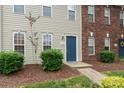 A close-up of townhome number 108 with neutral siding, blue front door, and manicured landscaping at 128 Locomotive Ln, Mooresville, NC 28115