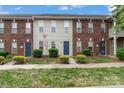 Street view of brick and siding townhomes, showcasing neat landscaping, blue doors, and a well-kept exterior at 128 Locomotive Ln, Mooresville, NC 28115
