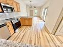 Kitchen area with stainless appliances, wood cabinets, and hardwood floors at 1657 Diary Dr, Rock Hill, SC 29730