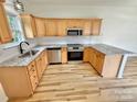 Modern kitchen with stainless steel appliances, granite countertops, and light wood floors at 1657 Diary Dr, Rock Hill, SC 29730
