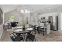 Open-concept dining area with modern chandelier, breakfast bar and stainless steel appliances at 213 E Division Ave, Salisbury, NC 28144