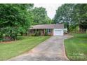 Inviting home exterior with a long driveway, green lawn, and mature trees providing shade and character at 2418 Live Oak Ct, Gastonia, NC 28056