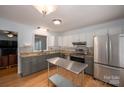 Bright kitchen with stainless steel appliances, granite countertops, and a functional center island at 2418 Live Oak Ct, Gastonia, NC 28056