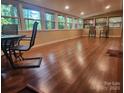 A spacious sunroom featuring hardwood floors and multiple windows at 2461 Ridgecrest Dr, Stanley, NC 28164