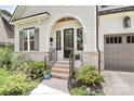 Charming front entrance featuring brick steps, modern black door, and lush landscaping surrounding the home, curb appeal at 2600 Palm Ave, Charlotte, NC 28205