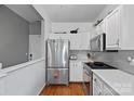 Modern kitchen boasts stainless steel appliances, white cabinets, and a stylish gray backsplash at 2625 E 5Th St # F, Charlotte, NC 28204