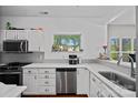 Bright kitchen featuring white cabinets, stainless steel appliances, and a window with backyard views at 2625 E 5Th St # F, Charlotte, NC 28204