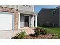 Close up of the front entry featuring a dark wood door, neutral siding, and manicured landscaping at 2641 Goose Fair Rd # 88, Maiden, NC 28650