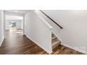Hallway featuring hardwood floors with view to the living room and carpeted stairs with wooden handrail at 2641 Goose Fair Rd # 88, Maiden, NC 28650