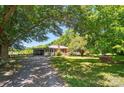 Quaint single-story home with a brick chimney and a covered parking area surrounded by lush greenery at 2722 Catawba Church Rd, Rock Hill, SC 29730