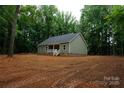 Back exterior of a charming single-story home, surrounded by lush trees and a spacious yard at 3452 Hands Mill Hwy, York, SC 29745