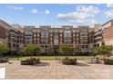 Beautiful condo courtyard featuring manicured lawn, mature trees, and seating area for residents at 400 N Church St # 422, Charlotte, NC 28202