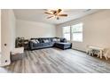 Bright living room with a cozy gray sofa, neutral walls, and large windows at 415 Kickapoo Ave, Gastonia, NC 28056