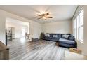 Open-concept living room with a gray sofa, ceiling fan, and hardwood floors at 415 Kickapoo Ave, Gastonia, NC 28056