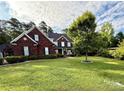 Brick home featuring a well-manicured lawn, mature trees, and a sidewalk leading to the front entrance at 4230 Berry Hill Ct, Concord, NC 28025