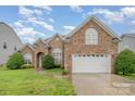 Charming brick home with well-maintained lawn, arched windows, and a two-car garage at 5052 Ashley Pl, Bessemer City, NC 28016