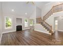 Spacious living room with hardwood floors, fireplace, and natural light from multiple windows at 6655 Maple Spring Ct, Denver, NC 28037
