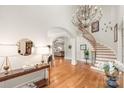 Spacious foyer featuring a curved staircase, hardwood floors, and stylish decor, creating an inviting atmosphere at 7018 Dowington Dr, Charlotte, NC 28277