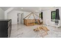 Spacious bedroom with marble floors, unique wooden play structure, and ample natural light at 8429 Meadowcroft Ct, Charlotte, NC 28215