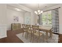 Bright dining area with elegant chandelier, wood floors, and modern striped curtains at 1020 Bannister Rd, Waxhaw, NC 28173