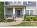 Welcoming front porch featuring stone accents, a well-maintained lawn, and attractive landscaping enhancing the entrance at 11209 Flenniken Ct, Charlotte, NC 28277