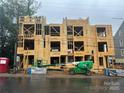 New townhome construction showing wood framing during building phase and equipment on site at 113 Verbena Ne St # 11, Charlotte, NC 28217