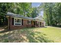 Beautiful brick home with black shutters and a charming front porch with white columns and an American flag at 114 Elmwood Dr, Salisbury, NC 28147
