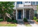 Attractive townhome entrance featuring a blue front door and manicured landscaping at 1142 Doveridge St, Charlotte, NC 28273